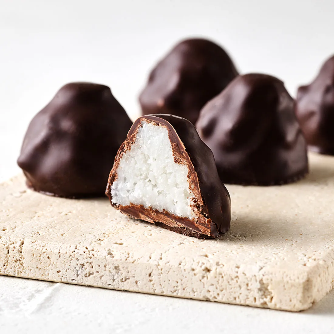 Stimmungsbild: Kokosflocke Praline mit Zartbitterschokolade dekorativ angeschnitten