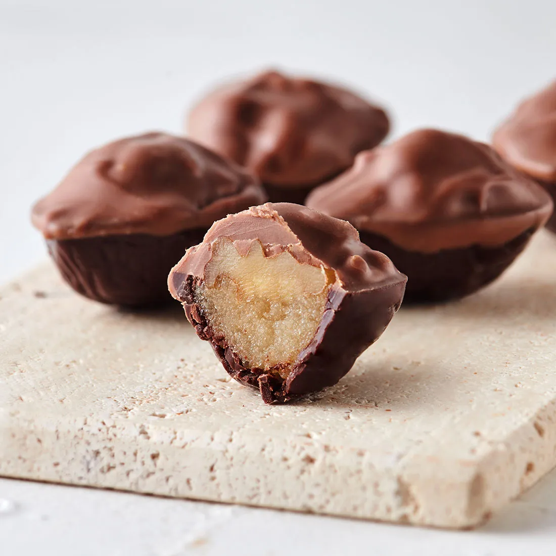 Produktbild: Walnuss auf Weinbrandmarzipan in Vollmilch- und Zartbitterschokolade angeschnitten