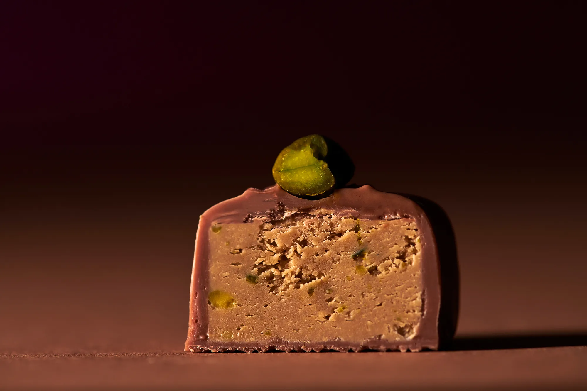 Pistazien-Nougat, 6 St. Makroaufnahme von einer aufgeschnittenen Pistazien-Nougat-Praline